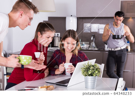Travelers planning tourist itinerary in hostel kitchen Travelers planning tourist itinerary in hostel kitchen 64348233