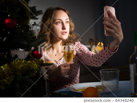 Young woman is posing for selfie in New Year night 64348240