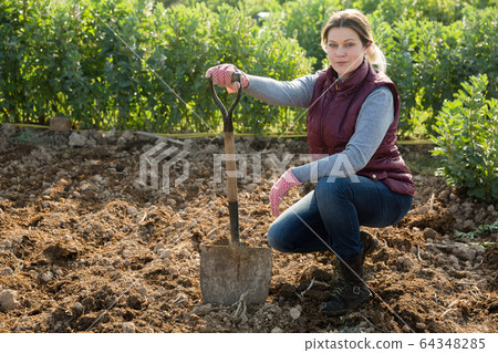 Woman working with shovel 64348285
