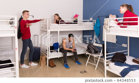 Travelers resting in hostel bedroom Travelers resting in hostel bedroom 64348553