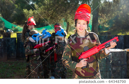 Portrait of smiling tween girl with marker gun 64348700