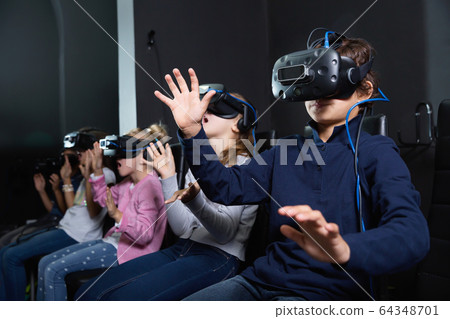 Enthusiastic children in virtual reality glasses in quest room 64348701