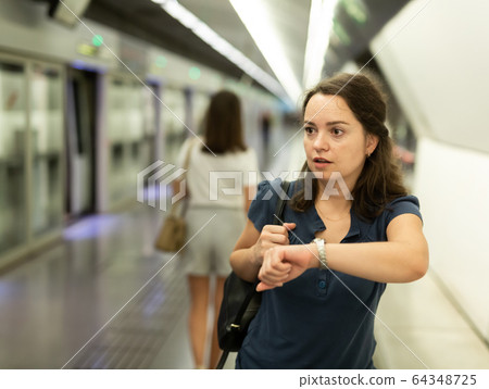 Hurrying woman is late for subway train Hurrying woman is late for subway train 64348725