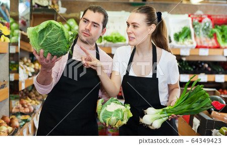 Two sellers inspecting vegetables Two sellers inspecting vegetables 64349423