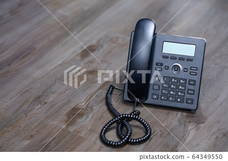 Close Up Black ip phone is placed on a wooden 64349550