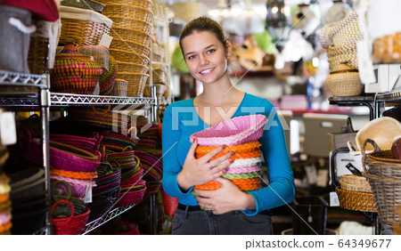 Girl standing with pile of different wicker basket Girl standing with pile of different wicker basket 64349677