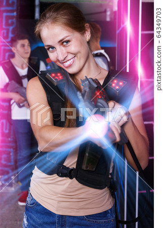 girl with laser pistol in her hands playing laser tag game 64349703