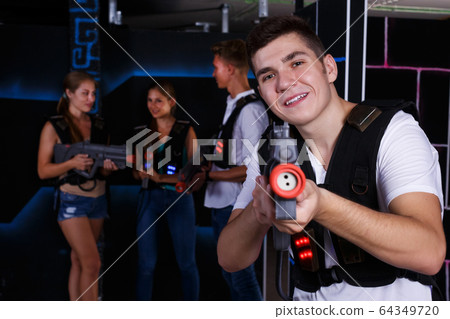guy holding laser pistol playing laser tag game guy holding laser pistol playing laser tag game 64349720