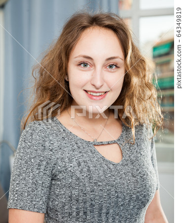 Smiling woman posing in living room interior Smiling woman posing in living room interior 64349819