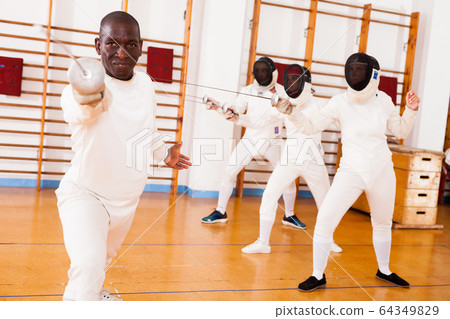 Sporty african american man fencer practicing effective fencing techniques 64349829