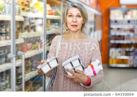 Adult lady shopping for milk products Adult lady shopping for milk products 64350004