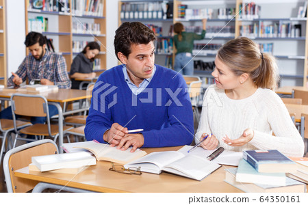 Young people preparing for exam in library Young people preparing for exam in library 64350161