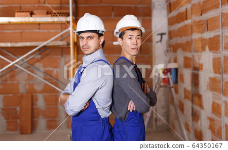 Builders doing finishing work Builders doing finishing work 64350167