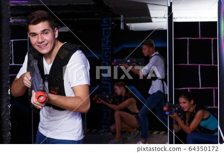 guy holding laser pistol playing laser tag game guy holding laser pistol playing laser tag game 64350172