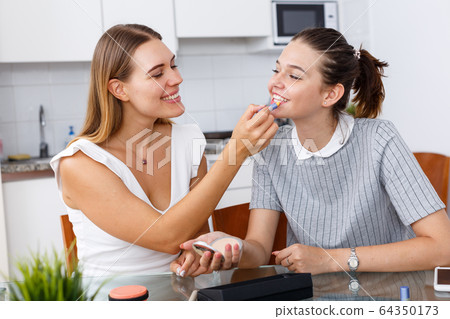 Friends talking and applying make up Friends talking and applying make up 64350173