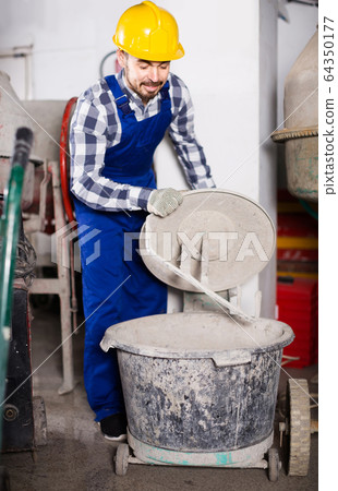 working man practicing his skills with mixing unit at workshop working man practicing his skills with mixing unit at workshop 64350177