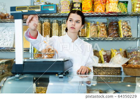 Girl in uniform selling candied fruits and nuts Girl in uniform selling candied fruits and nuts 64350229