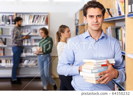 Man standing in library Man standing in library 64350232