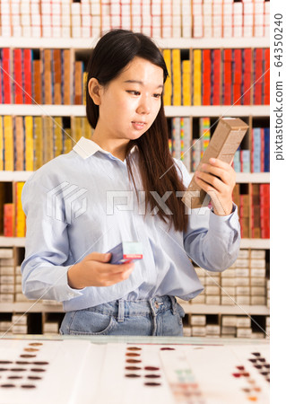 Woman buying hair dye products Woman buying hair dye products 64350240