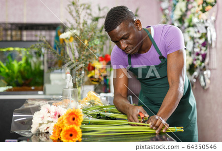 Man creating floral arrangement with gerberas 64350546