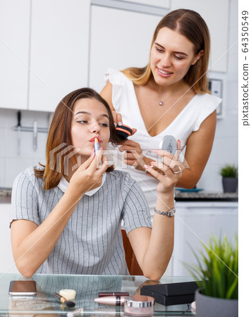 Two girls applying make up Two girls applying make up 64350549