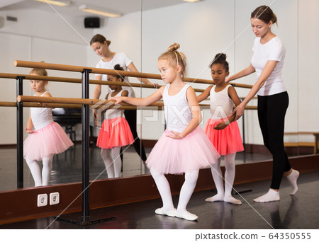 Teacher helping her little ballerinas Teacher helping her little ballerinas 64350555