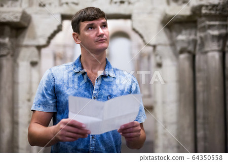 Man with brochure looking at exposition Man with brochure looking at exposition 64350558