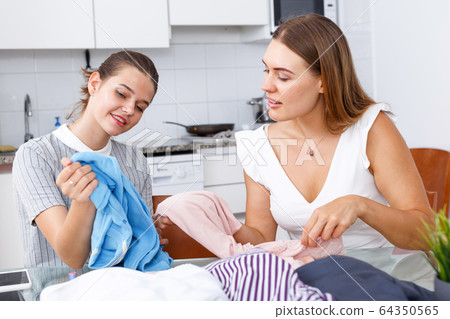 Friends demonstrating each other clothes 64350565
