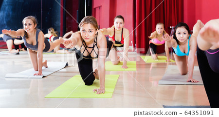 Women exercising yoga poses in fitness center Women exercising yoga poses in fitness center 64351091