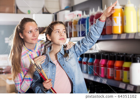 Mother and daughter holding jar with color paint Mother and daughter holding jar with color paint 64351102