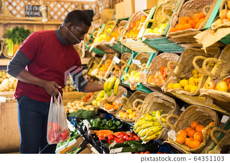 Man shopping in fruits and vegetables store Man shopping in fruits and vegetables store 64351103