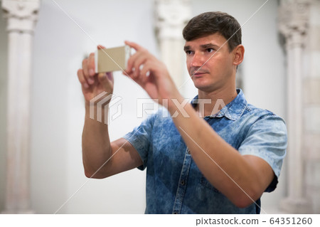 Man taking photo of exposition 64351260