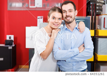 Young loving couple standing in specialty workshop of safes Young loving couple standing in specialty workshop of safes 64351261