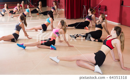 Group of young active females training zumba 64351318
