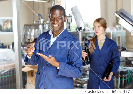 Winery worker testing new wine Winery worker testing new wine 64351437