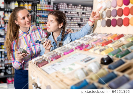 Mother and daughter holding jar with color paint Mother and daughter holding jar with color paint 64351595