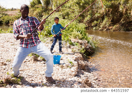 Man fishing and pulling fish Man fishing and pulling fish 64351597