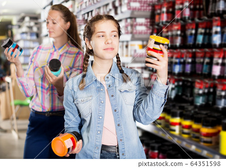 Mother and daughter holding jar with color paint Mother and daughter holding jar with color paint 64351598