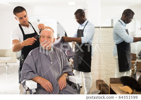 Aged male client getting haircut Aged male client getting haircut 64351599