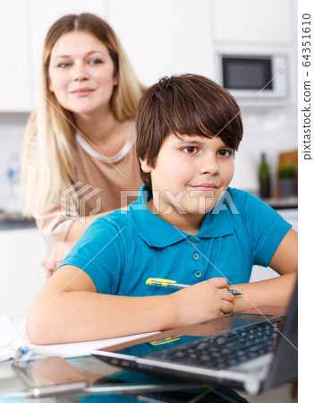 Family doing homework at kitchen Family doing homework at kitchen 64351610