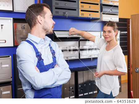 Woman choosing postbox with seller Woman choosing postbox with seller 64351629