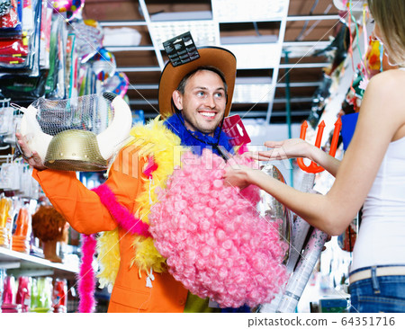 Pair of people having fun in festive accessories shop Pair of people having fun in festive accessories shop 64351716