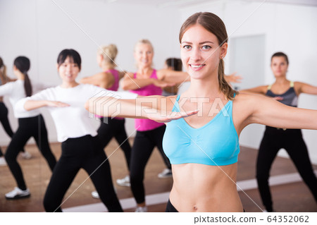 Group of active smiling people dancing together in dance studio 64352062