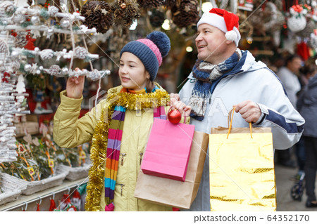 Girl with father choosing Xmas decoration Girl with father choosing Xmas decoration 64352170