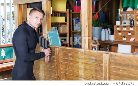 guy dressed wetsuit standing next to reception 64352175