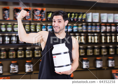 Attractive muscular man showing his biceps Attractive muscular man showing his biceps 64352258