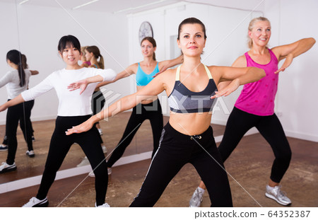 Fitness women practicing zumba movements 64352387