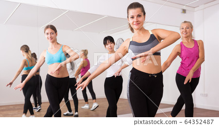 Fitness women practicing zumba movements 64352487