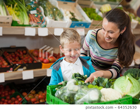 Mother with little boy buying broccoli 64352630