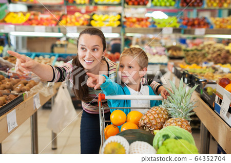 mother with little boy buying fruits and vegetables at store 64352704